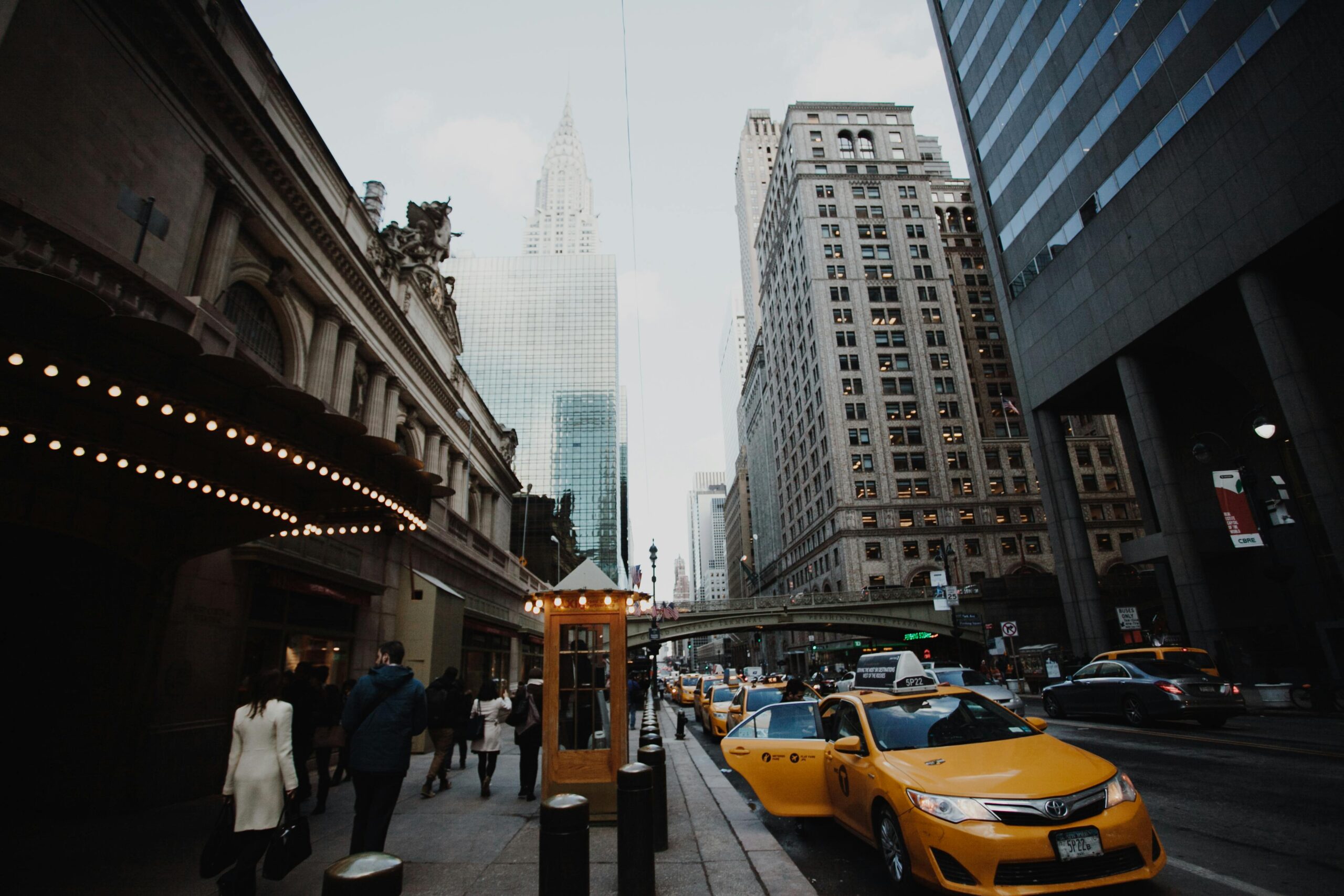 Dynamic view of a lively NYC street with iconic skyscrapers and yellow taxis.