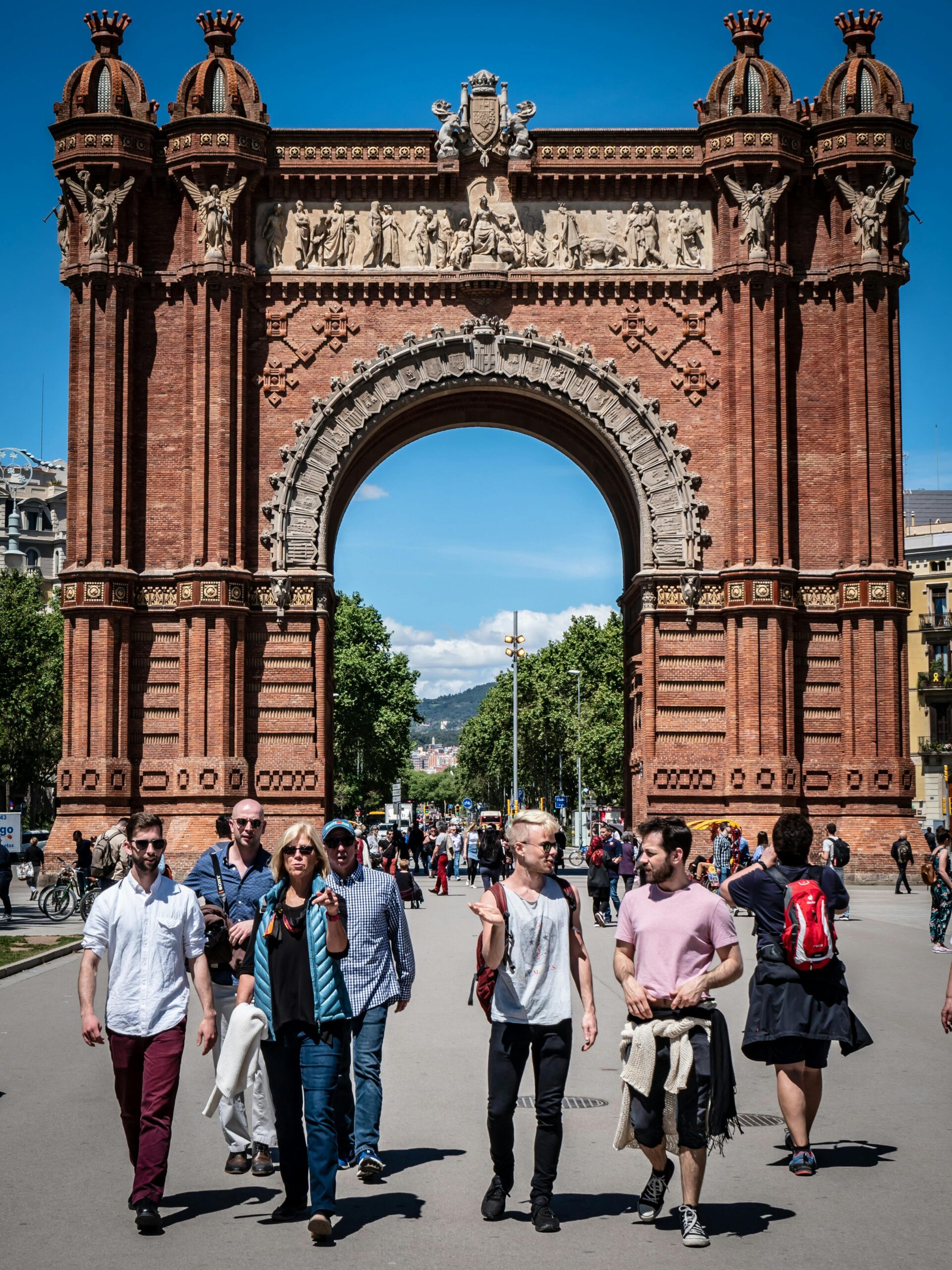 People enjoying a sunny day at the iconic Arc de Triomf in Barcelona, a famous historical landmark.