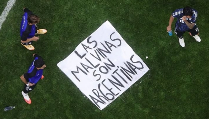 Argentina football team celebrating their World Cup victory while displaying the Falklands banner during post-match celebrations.