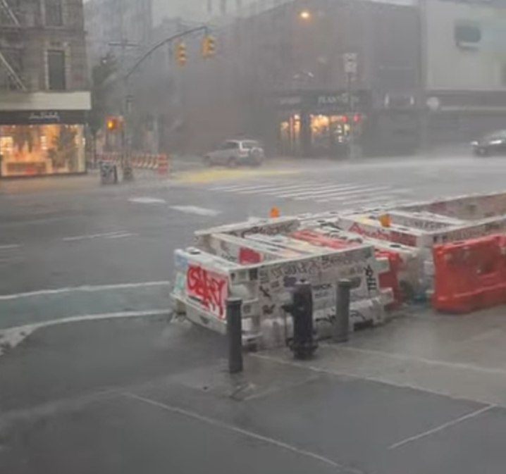 Vehicles driving through flooded roads in New York City during heavy rainstorm