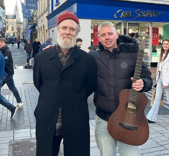 Glen Hansard performing live with an acoustic guitar