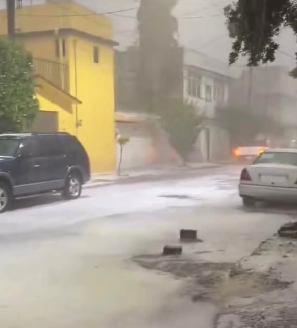 Large hailstones falling on a road during a thunderstorm